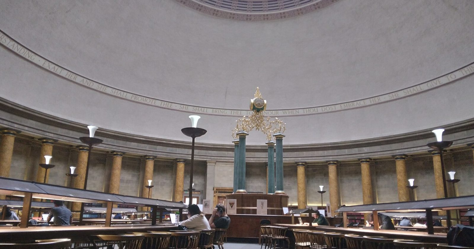 Czytelnia publicznej biblioteki miejskiej w Manchesterze — ludzie uczą się przy stołach pod zabytkowym sklepieniem