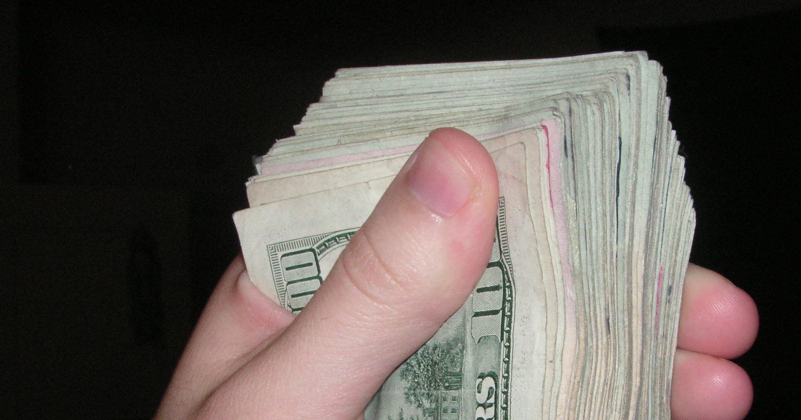 Banknoty trzymane w dłoni — pieniądze i wynagrodzenie za pracę
