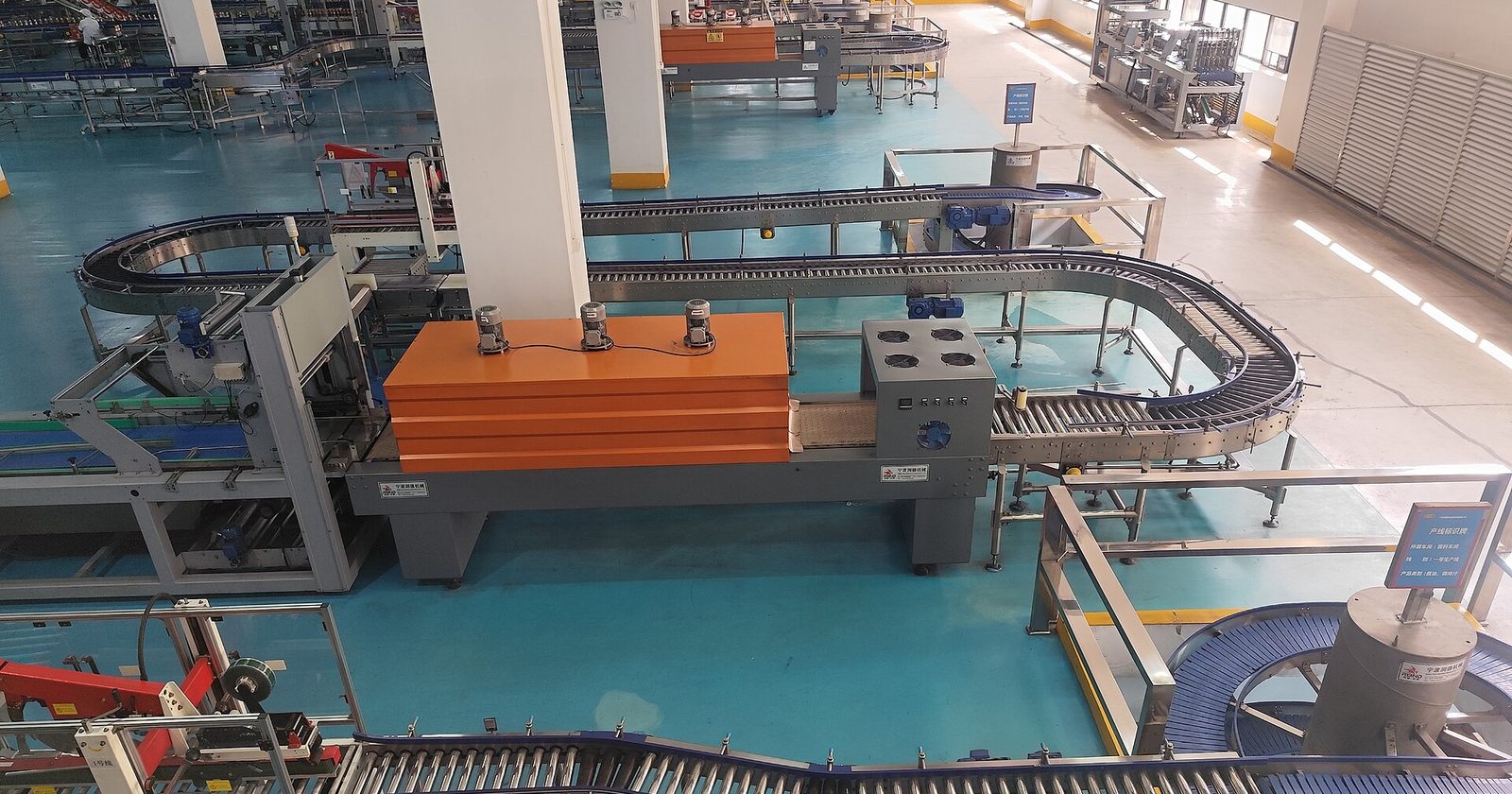 Hala fabryczna z automatyczną linią produkcyjną, taśmociągami rolkowymi i maszynami pakującymi