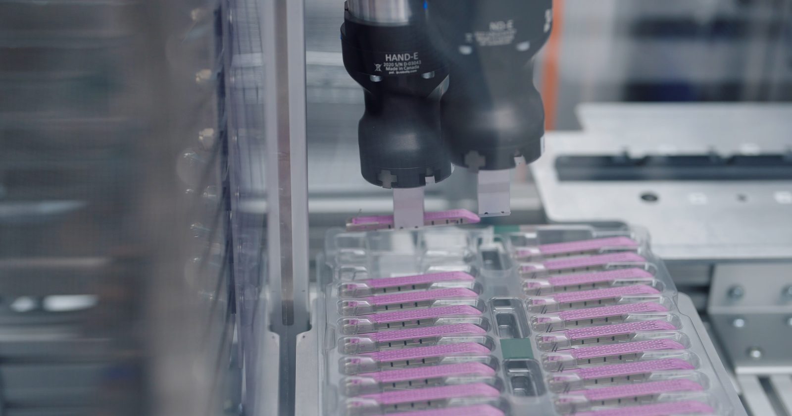 Przemysłowe ramię robota na zautomatyzowanej linii produkcyjnej zakładu wytwórczego.